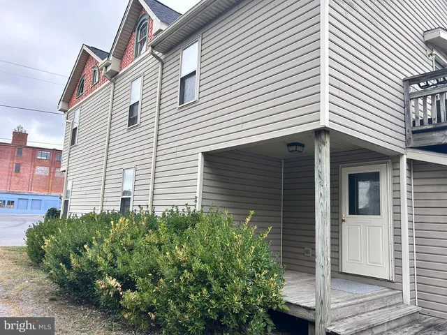 a view of a white house next to a yard