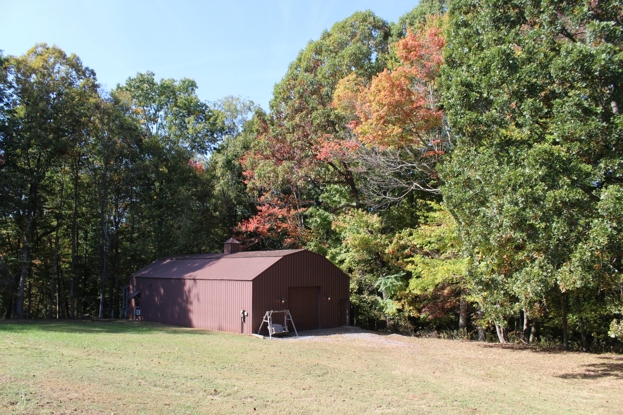 249 Claude Fox Road Lafayette, TN 37083 - Photo 28 of 68 a wooden bench sitting in middle of a field