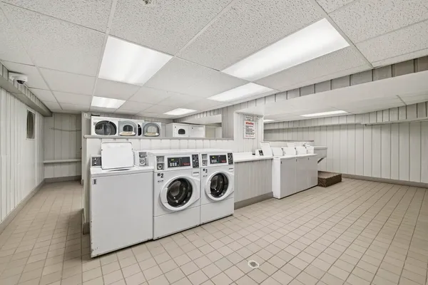 a utility room with dryer washer and a fridge