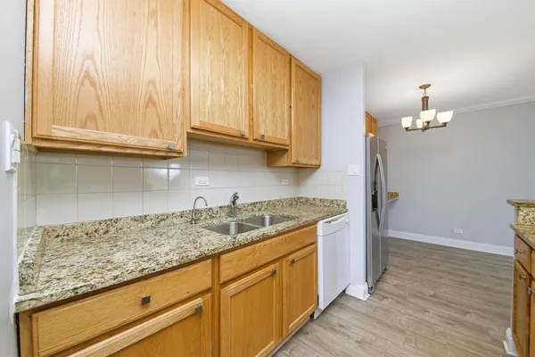 a kitchen with granite countertop wooden cabinets and a sink