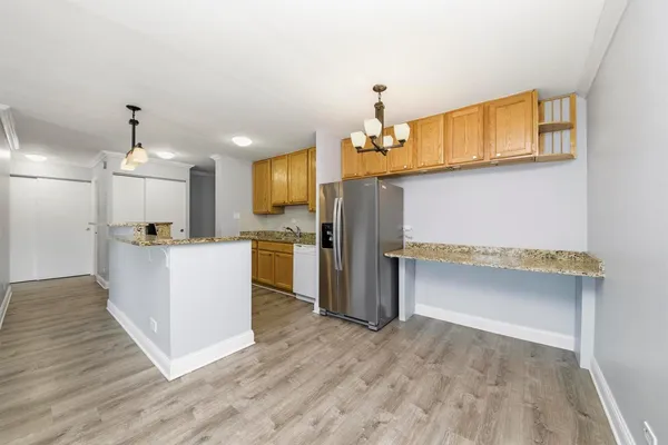 a view of kitchen with refrigerator microwave and wooden floor