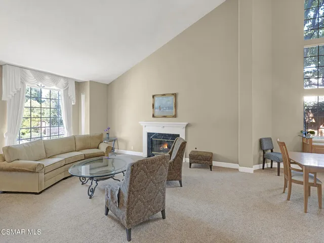 a living room with furniture a fireplace and a large window