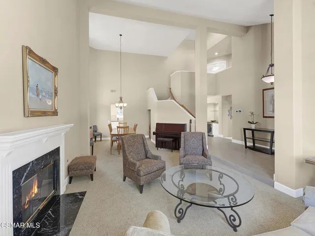 a living room with furniture a fireplace and a floor to ceiling window