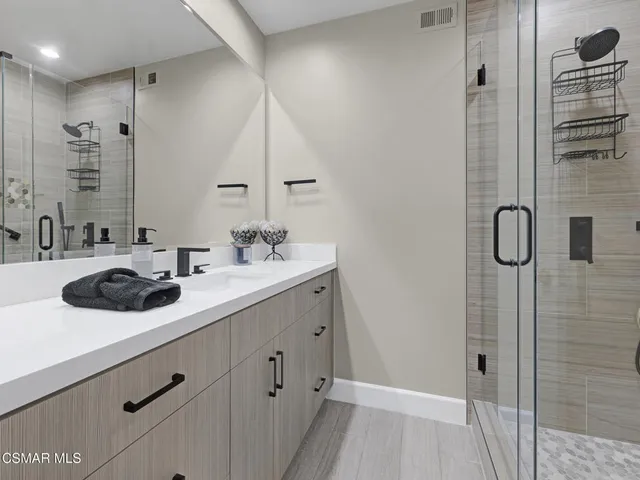 a bathroom with a double vanity sink a mirror and shower