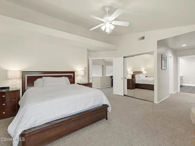a spacious bedroom with a bed and a chandelier