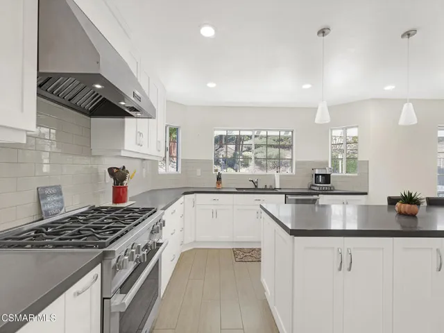 a kitchen with a stove a sink and a refrigerator