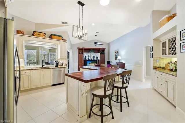 a kitchen with stainless steel appliances kitchen island granite countertop a stove a sink and a refrigerator