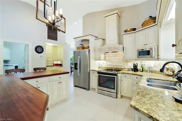 a kitchen with stainless steel appliances granite countertop a sink stove oven and refrigerator
