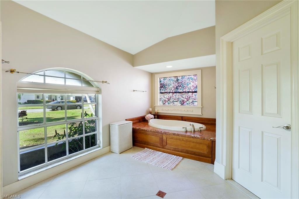 146 Muirfield Circle Naples, FL 34113 - Photo 18 of 31 a spacious bedroom with a bed and a window