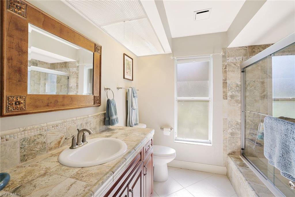 146 Muirfield Circle Naples, FL 34113 - Photo 22 of 31 a bathroom with a granite countertop sink and a mirror