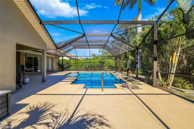 a backyard of a house with table and chairs under an umbrella