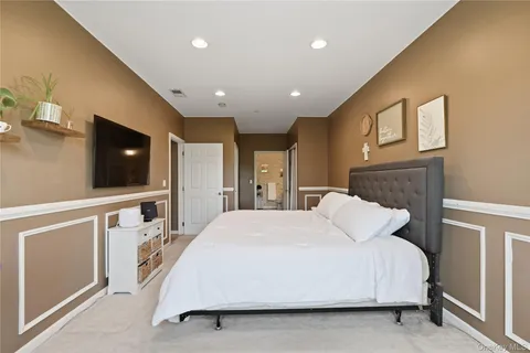 a bedroom with a large bed and a flat screen tv