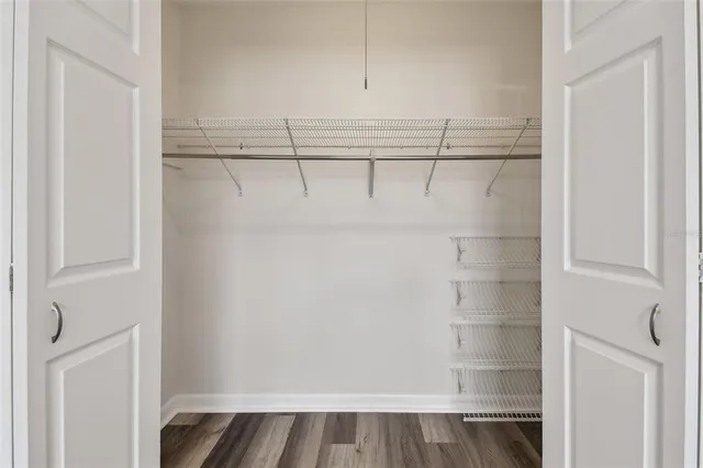a view of a room with wooden floor and a ceiling fan
