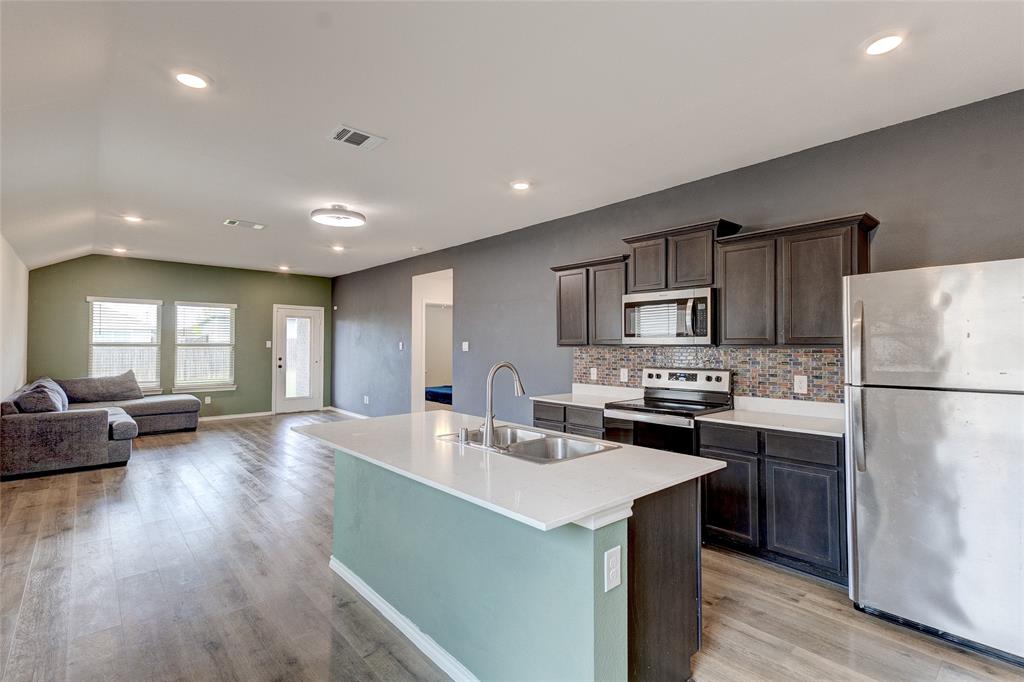 1016 Rio Bravo Drive Forney, TX 75126 - Photo 4 of 25 Open-concept living area featuring wood-finish flooring, recessed lighting, and a vaulted ceiling