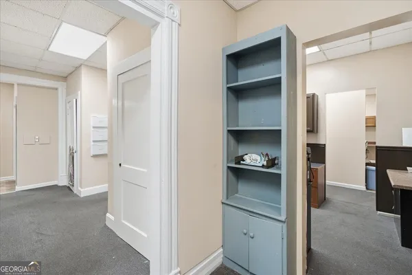 a view of a hallway with bathroom and mirror