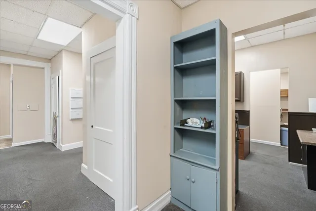 a view of a hallway with bathroom and mirror