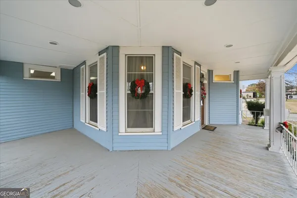 a view of a hallway with wooden floor and furniture