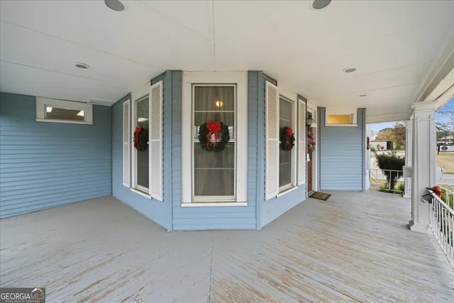 a view of a hallway with wooden floor and furniture