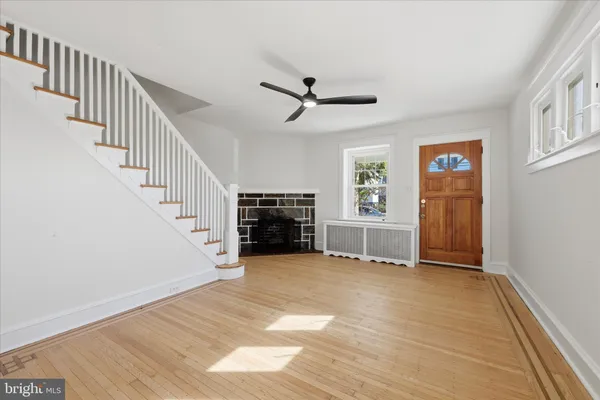 a view of a livingroom with wooden floor and a ceiling fan