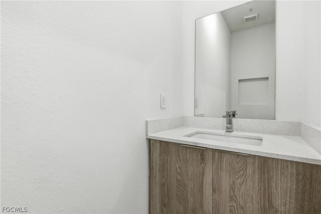 1253 Argosy Road LaBelle, FL 33935 - Photo 26 of 35 a bathroom with a sink and a mirror