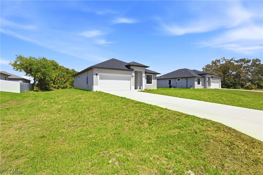 1253 Argosy Road LaBelle, FL 33935 - Photo 34 of 35 a front view of a house with a garden and yard