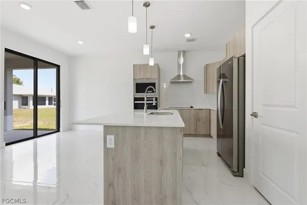 a kitchen with stainless steel appliances a refrigerator and a sink