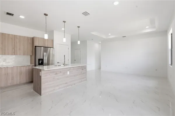 a large kitchen with kitchen island white cabinets and stainless steel appliances
