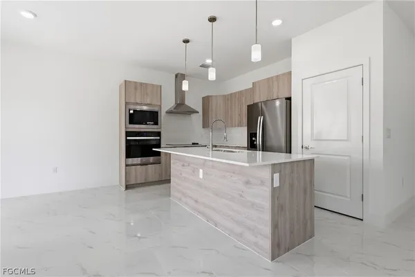 a kitchen with kitchen island a counter top space appliances and cabinets