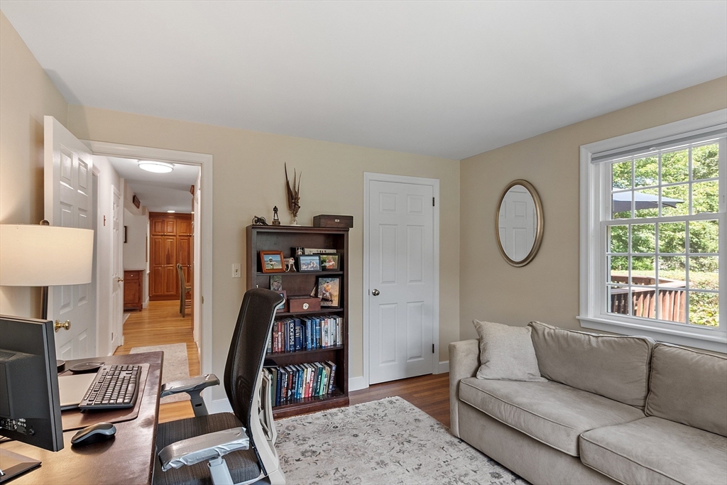 27 Mill Lane Littleton, MA 01460 - Photo 16 of 38 a living room with furniture a bookshelf and a window