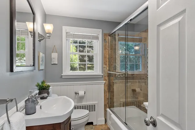 a bathroom with a tub a sink and mirror