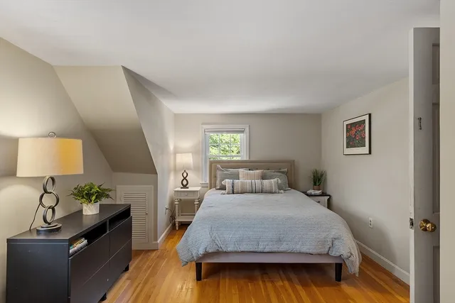 a bedroom with a bed and a lamp on dresser