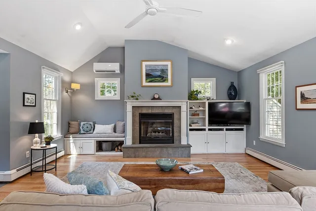 a living room with furniture a fireplace and a flat screen tv