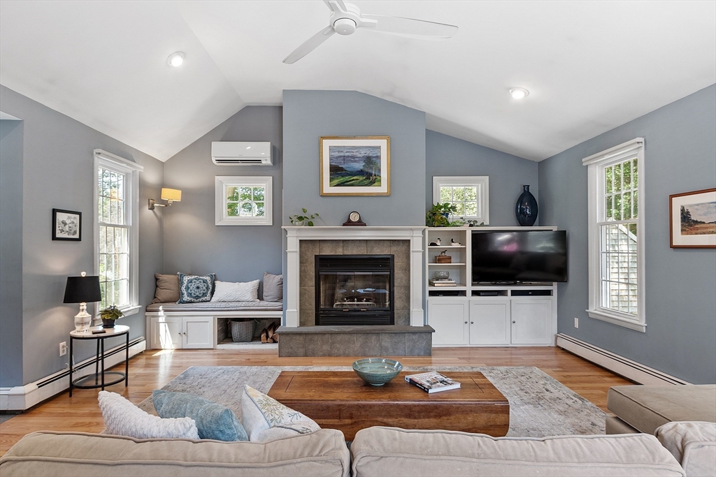 27 Mill Lane Littleton, MA 01460 - Photo 6 of 38 a living room with furniture a fireplace and a flat screen tv