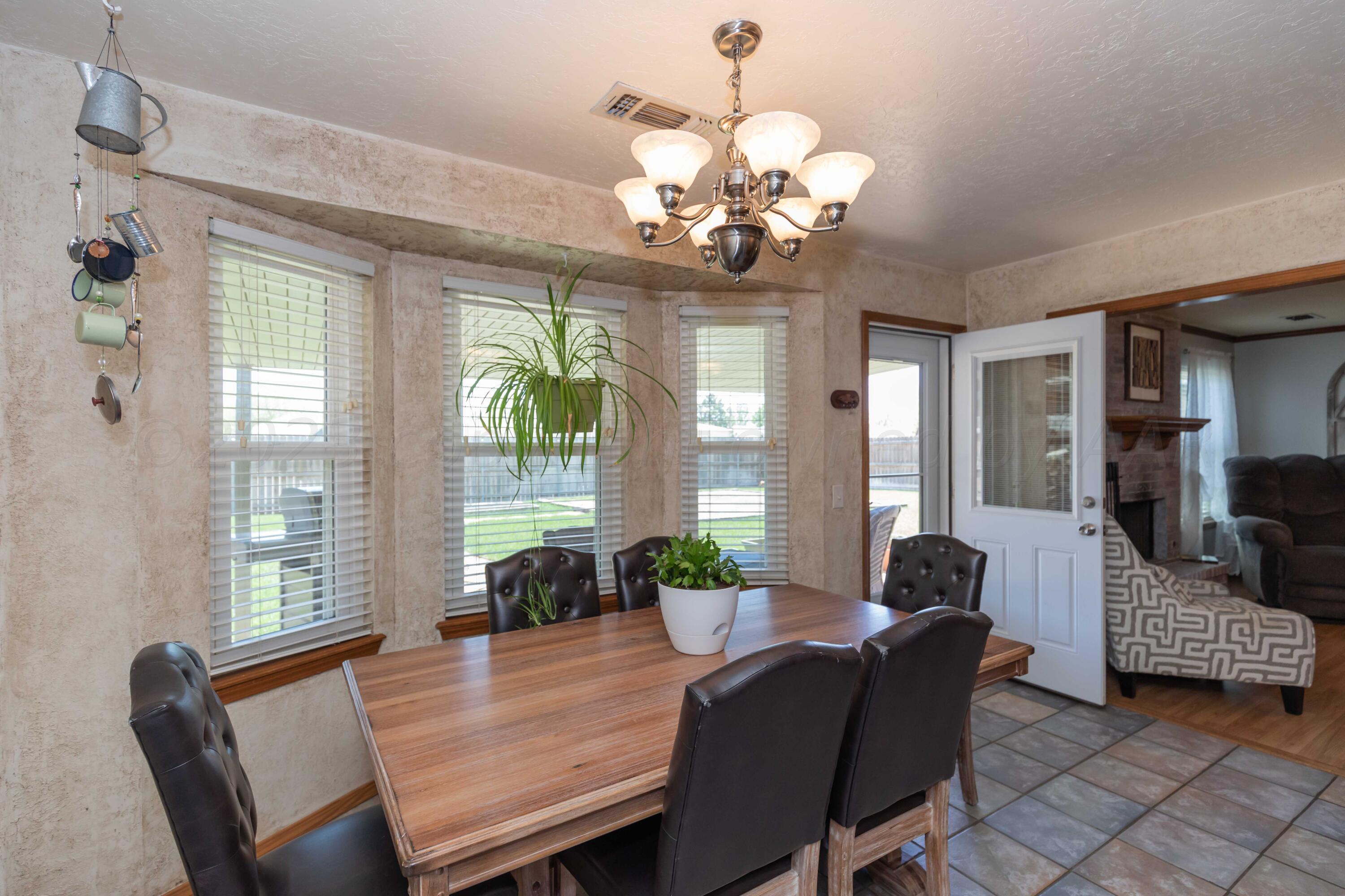 4205 Jamie Trail Amarillo, TX 79110 - Photo 11 of 36 a view of a dining room with furniture a chandelier and wooden floor