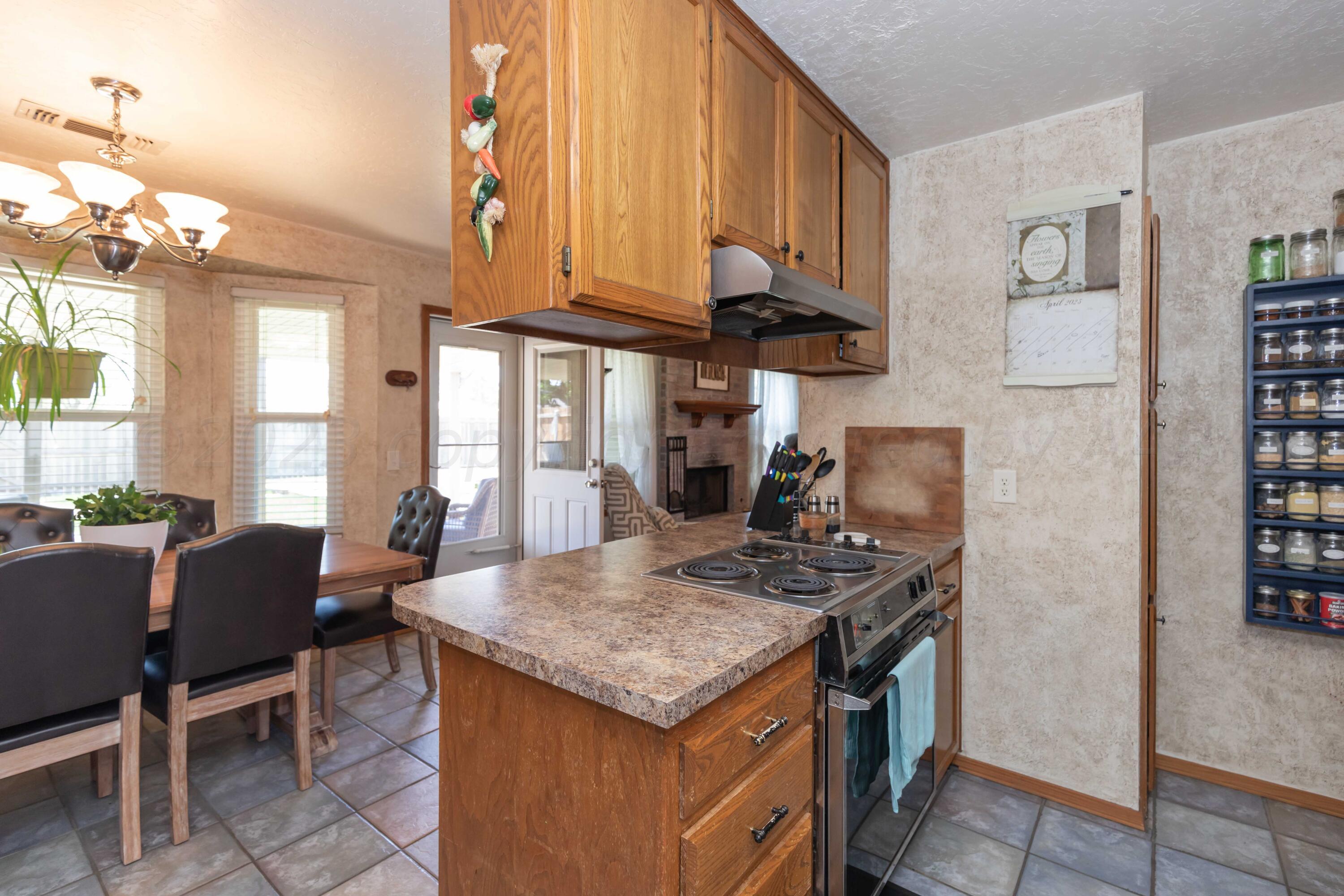 4205 Jamie Trail Amarillo, TX 79110 - Photo 14 of 36 a kitchen with stainless steel appliances granite countertop a stove a refrigerator a dining table and chairs with wooden floor