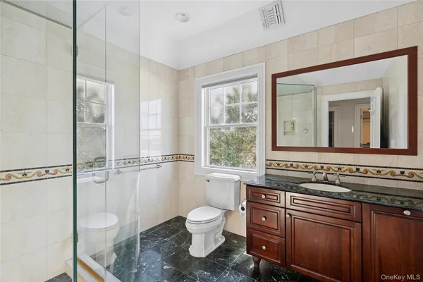 a bathroom with a toilet a sink and a window