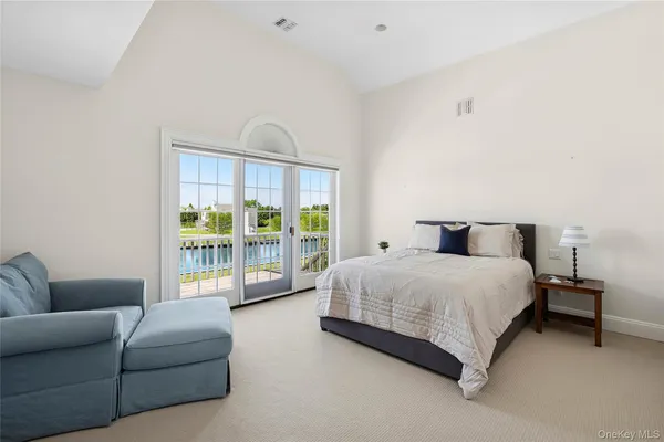 a spacious bedroom with a bed couch and a large window