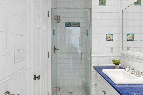 a bathroom with a sink shower and a mirror
