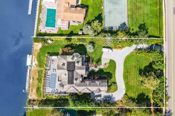 an aerial view of a house with a garden and lake view