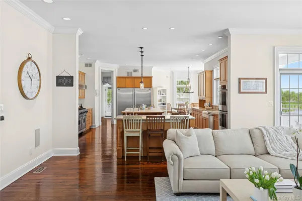 a living room with furniture a rug kitchen view and a large window