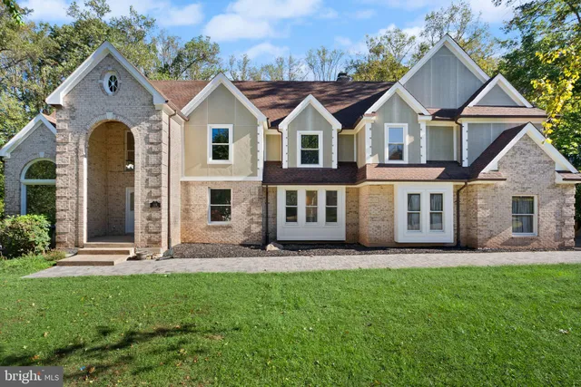 a front view of a house with a yard and trees