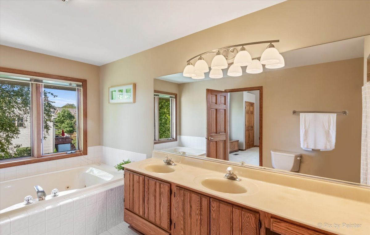 35W723 Parsons Road Algonquin, IL 60102 - Photo 23 of 52 a bathroom with a bathtub a sink and a large mirror