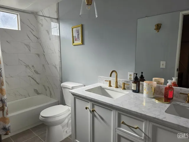 a bathroom with a granite countertop sink a toilet and shower