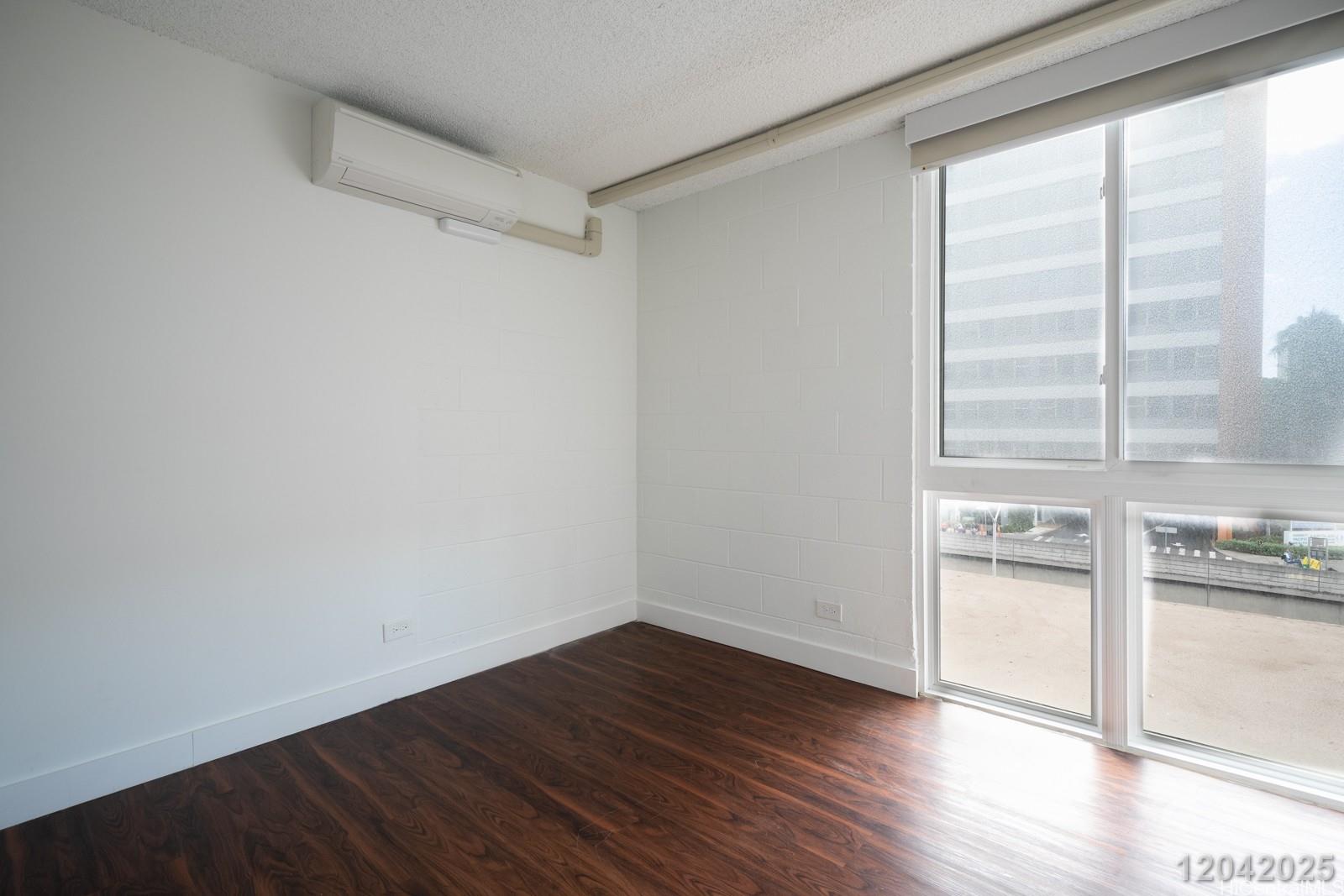 1415 Punahou Street, Unit 306 Honolulu, HI 96822 - Photo 14 of 19 a view of empty room with wooden floor and kitchen view