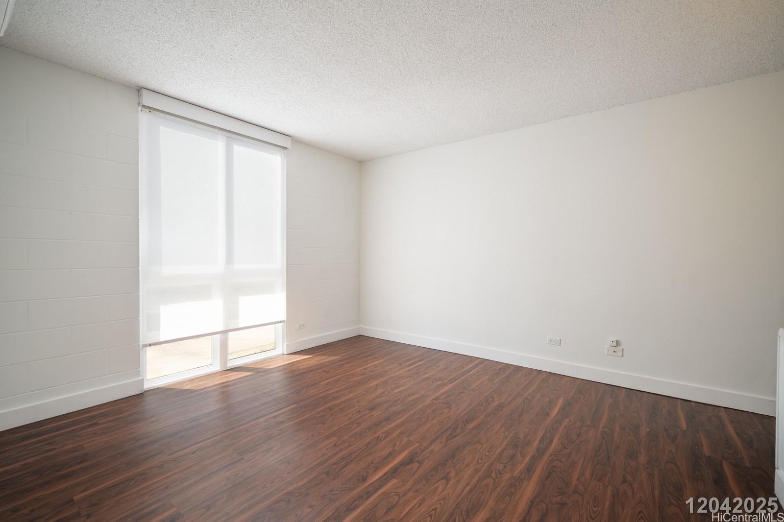 1415 Punahou Street, Unit 306 Honolulu, HI 96822 - Photo 16 of 19 an empty room with wooden floor and windows