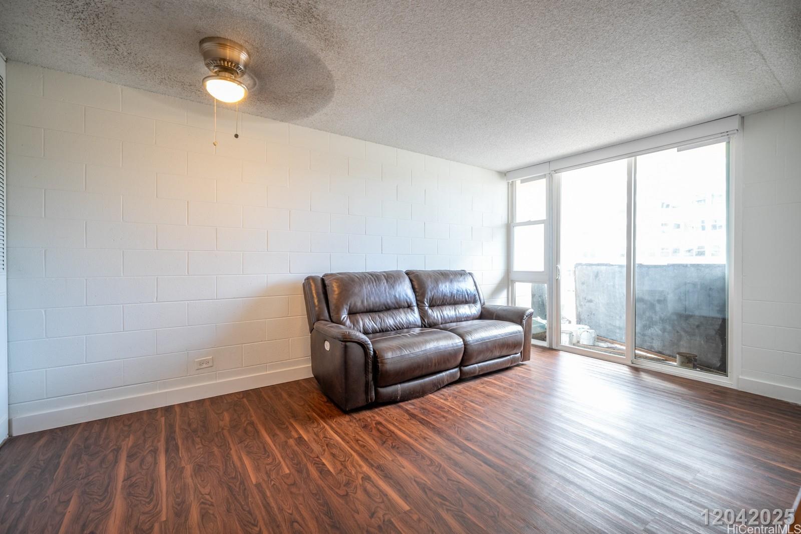 1415 Punahou Street, Unit 306 Honolulu, HI 96822 - Photo 7 of 19 a living room with a couch wooden floor and a large window