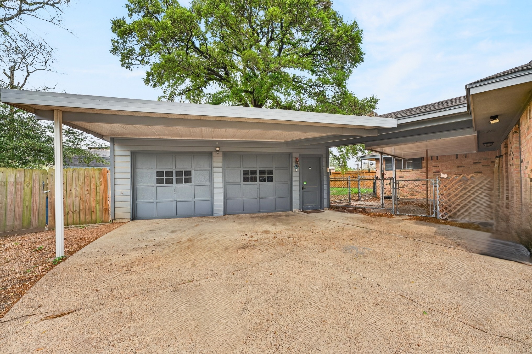 304 Fullen Street Conroe, TX 77301 - Photo 3 of 25 A detached garage building, attached by a carport, opens up possibilities for your toys or hobbies PLUS covered parking.