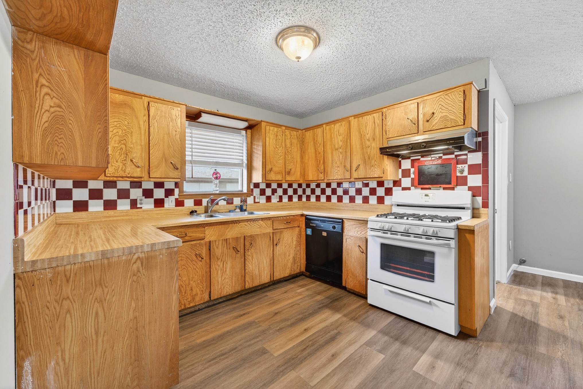 304 Fullen Street Conroe, TX 77301 - Photo 7 of 25 The kitchen layout has the perfect place for your coffee pot and other small appliances on the counter beside the fridge, and a nostalgic soda shop vibe with the red and white checkered backsplash!