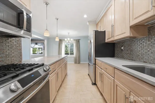 a kitchen with stainless steel appliances a sink stove and refrigerator