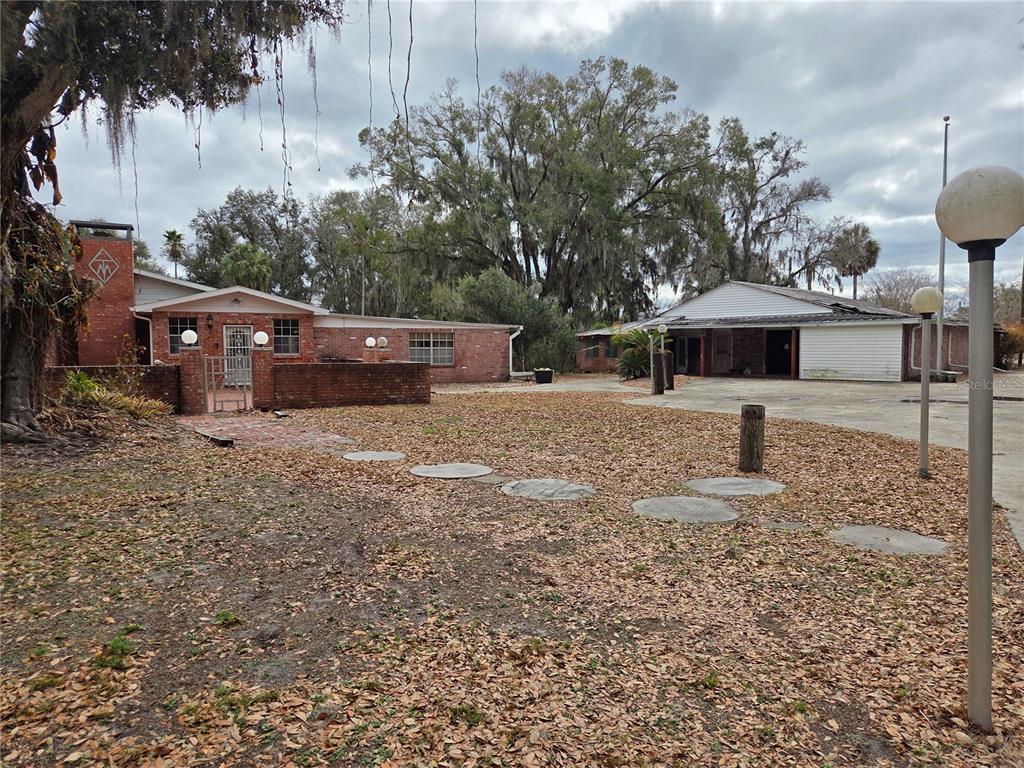 4911 West Sam Allen Road Plant City, FL 33565 - Photo 10 of 11 a table and chairs under an umbrella in front of house